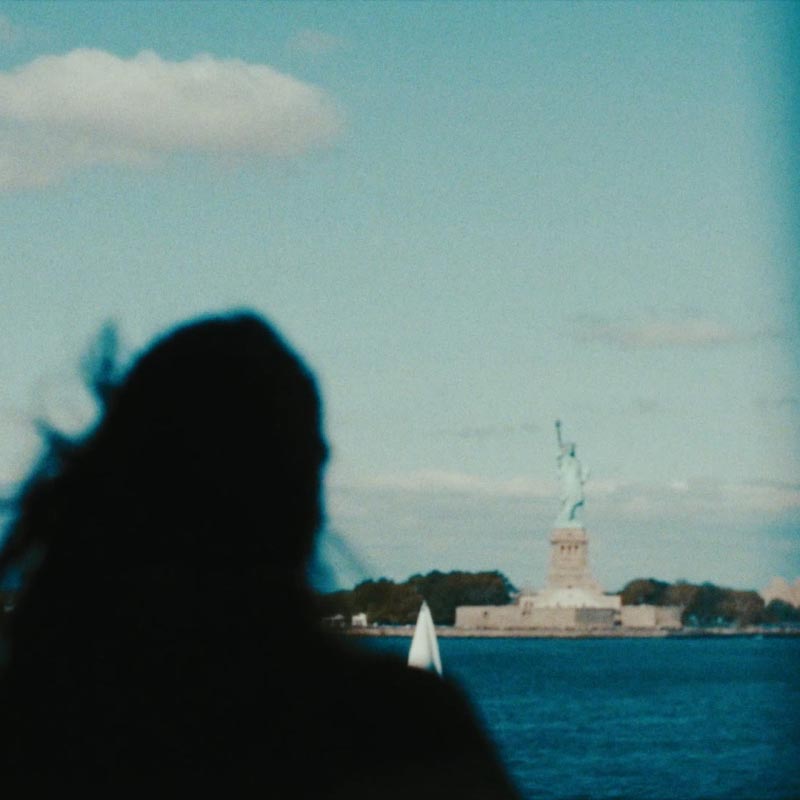 Frau schaut auf die Freiheitsstatue von New York